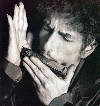 Боб Дилан играет на губной гармошке